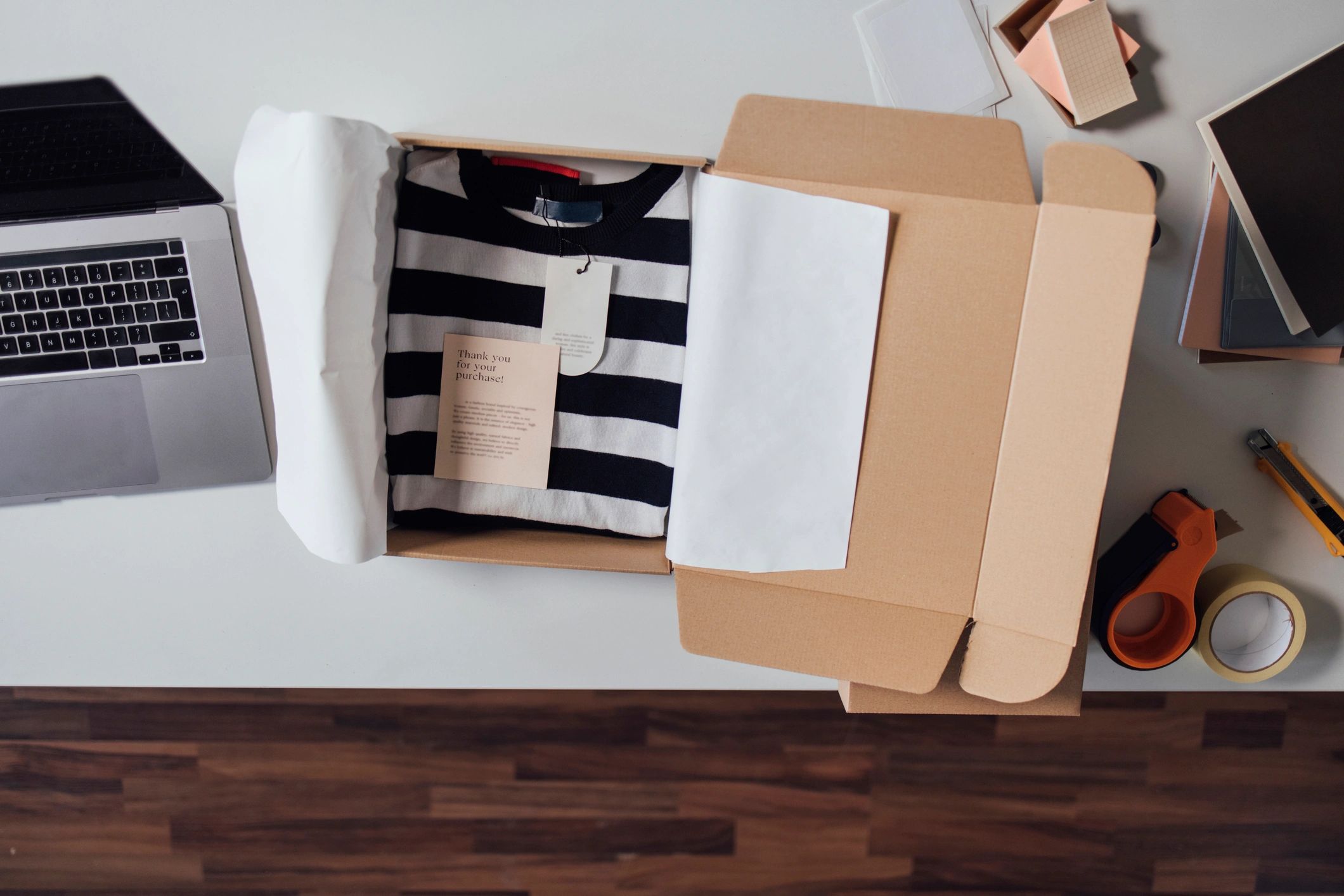 Clothes wrapped in paper inside a cardboard shipping box