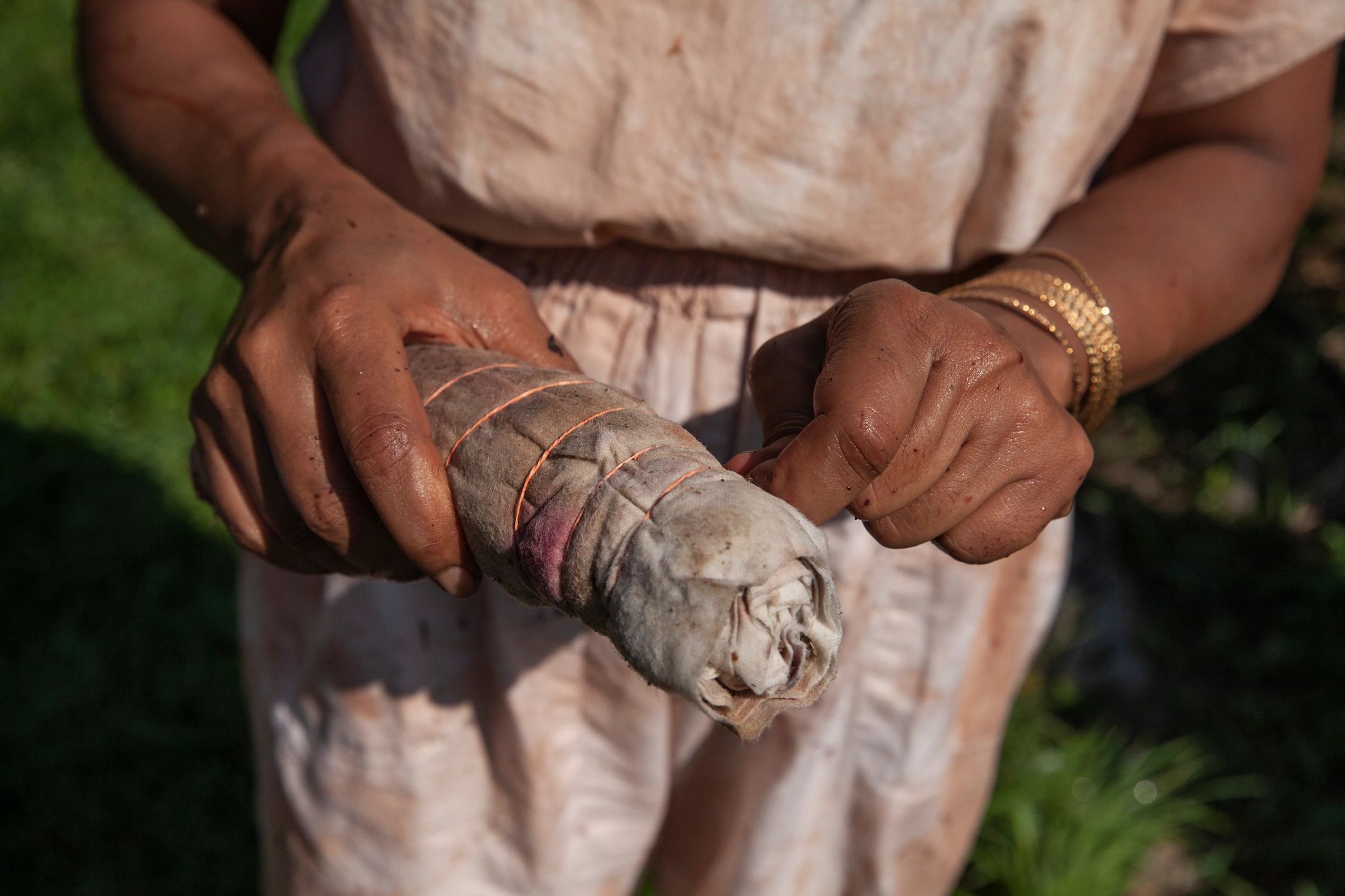 Hands holding tie-dyed cloth outdoors